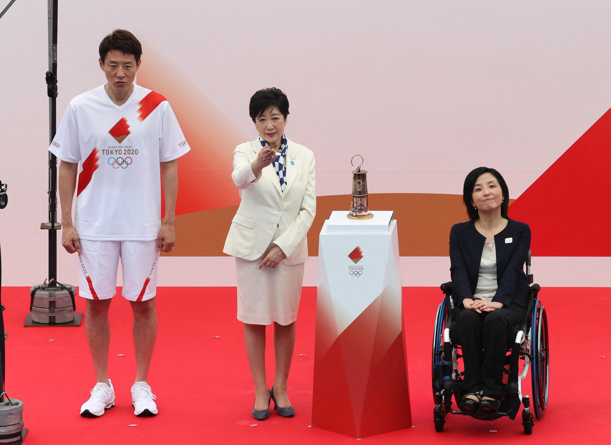 La flamme olympique a été remise à la gouverneure de Tokyo, Yuriko Koike (au centre). [The Yomiuri Shimbun via AFP - MIHO TAKAHASHI]