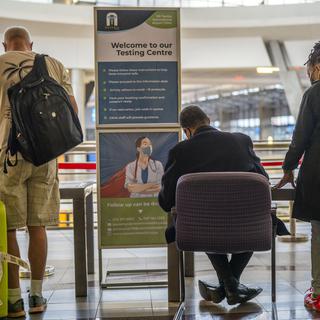Des personnes font la queue pour passer un test de dépistage du Covid à l'aéroport OR Tambo de Johannesburg, en Afrique du Sud, vendredi 26 novembre 2021. [Jerome Delay - AP Photo/Keystone]