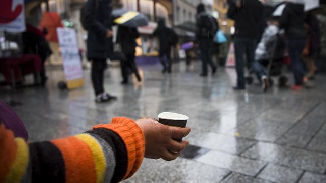 Une personne mendie sur la place St-Laurent à Lausanne, le 26 octobre 2016. [Keystone - Jean-Christophe Bott]