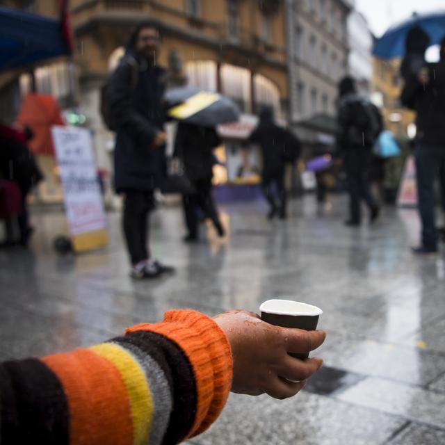 Une personne mendie sur la place St-Laurent à Lausanne, le 26 octobre 2016. [Keystone - Jean-Christophe Bott]