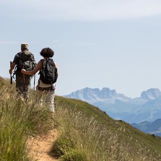 Des promeneurs dans les Grisons avec en toile de fond le massif alpin de Rätikon. [Keystone - Arno Balzarini]