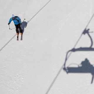 Des personnes profitent du soleil et de la neige pour faire du ski sur les pistes du domaine skiable ce vendredi 6 avril 2018 a Crans-Montana. [Keystone - Jean-Christophe Bott]