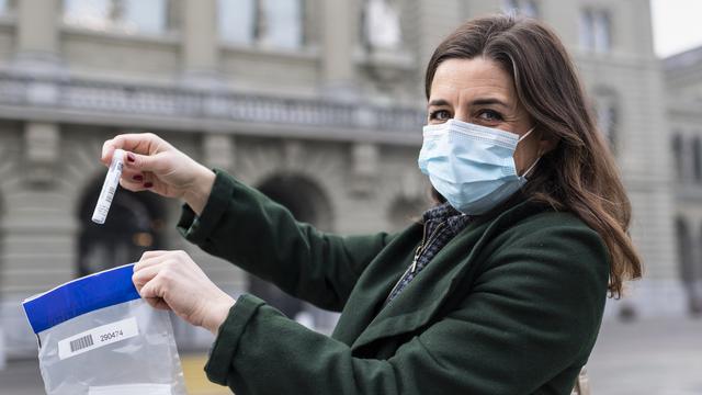 La conseillère nationale Flavia Wasserfallen (PS/Berne) montre son test salivaire Covid-19, avant de le mettre dans le sac prévu à cet effet, et de le rendre au Palais fédéral, le lundi 1er mars. [KEYSTONE - ALESSANDRO DELLA VALLE]