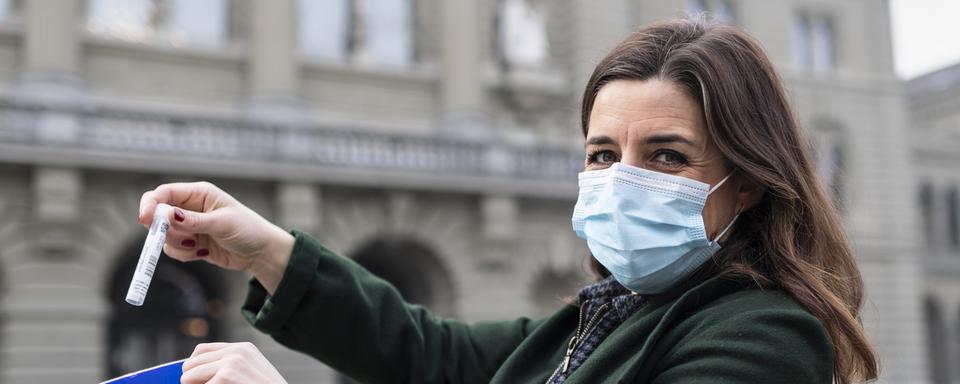 La conseillère nationale Flavia Wasserfallen (PS/Berne) montre son test salivaire Covid-19, avant de le mettre dans le sac prévu à cet effet, et de le rendre au Palais fédéral, le lundi 1er mars. [KEYSTONE - ALESSANDRO DELLA VALLE]