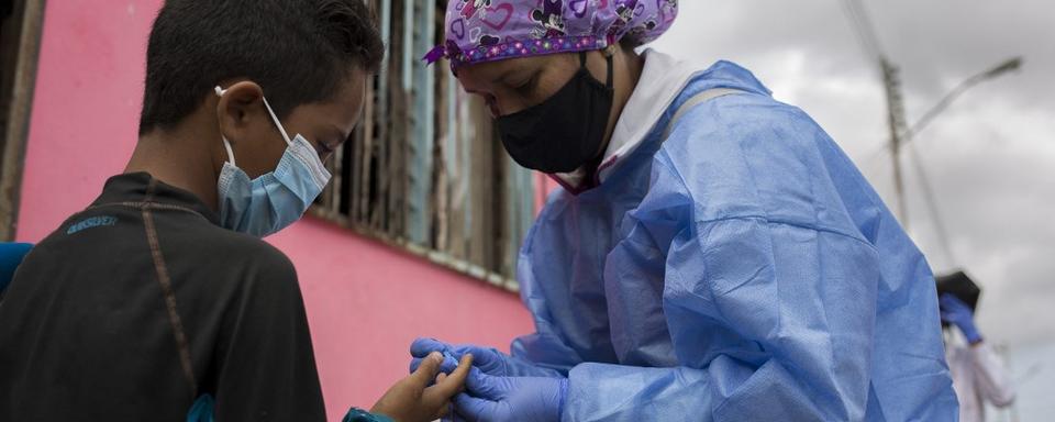 Une volontaire de Médecins Sans Frontières exécute un test pour la malaria sur un jeune patient à Barcelona, au Venezuela (2021). [AFP - Pedro Rances Mattey]