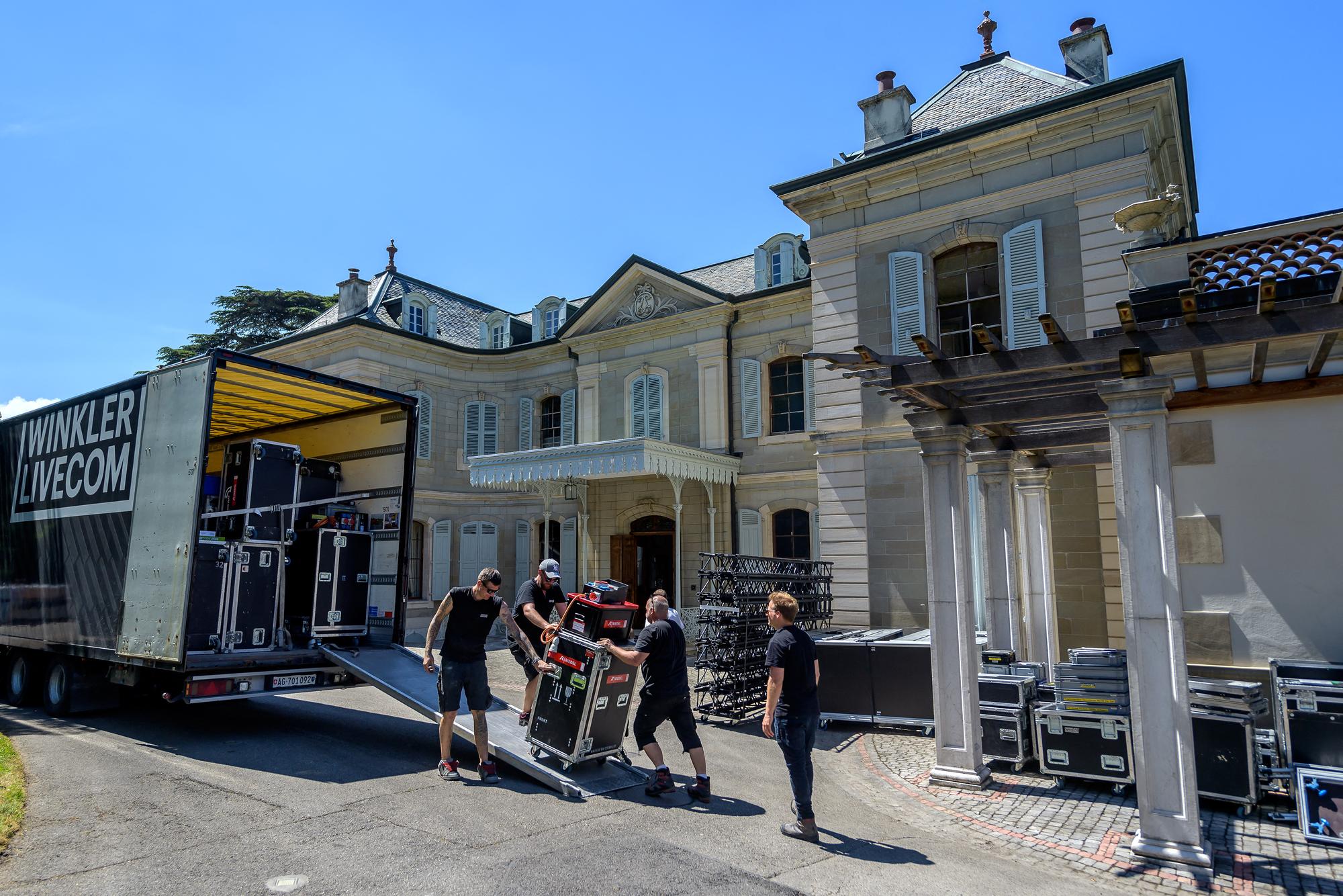 Une équipe décharge du matériel audio-visuel à la villa La Grange, le 11 juin 2021. [AFP - Fabric Coffrini]
