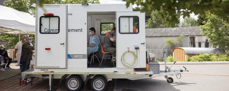 Des agents de la protection civile vaccinent contre le coronavirus sur le parking d'un magasin à Yverdon. [Keystone - Cyril Zingaro]