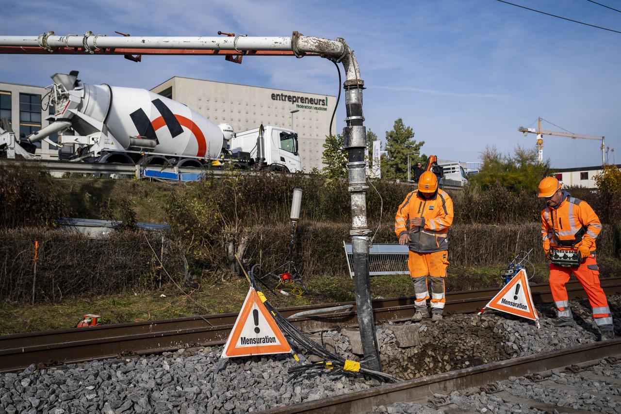 Des ouvriers tentent de boucher le trou de Tolochenaz avec du béton, le 10 novembre 2021. [Keystone - Sandra Hildebrandt]