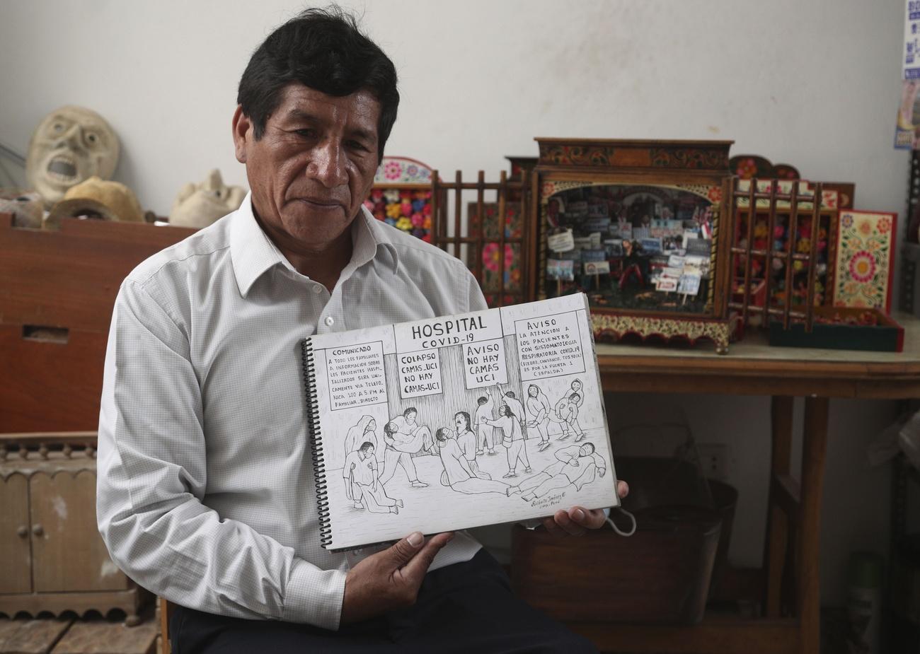 Edilberto Jimenez montre l'un de ses dessins représentant les souffrances de la population péruvienne dues à la pandémie de Covid-19. San Juan de Lurigancho, Pérou, le 20 mai 2021. [Keystone/AP Photo - Martin Mejia]