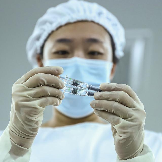 Un membre du personnel soignant tient dans ses mains des seringues contenant le vaccin anti-Covid du laboratoire Sinopharm, le 25 décembre 2020. [AP/Keystone - Zhang Yuwei]