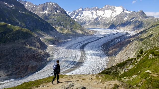 Une femme marche près du glacier d'Aletsch, en Valais. [KEYSTONE - Anthony Anex]