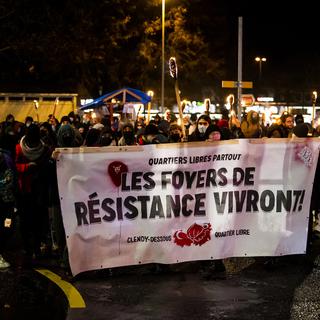 Les manifestants sur la place de la Gare d'Yverdon-les-Bains, lundi 27.12.2021. [Keystone - Jean-Christophe Bott]