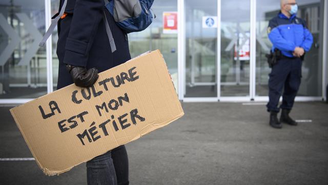 Une personne issue du milieu de la culture manifeste lors de l'arrivée des députés du Grand Conseil vaudois, lors de la deuxième vague de Covid-19. [KEYSTONE - LAURENT GILLIERON]