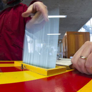 Une citoyenne met son bulletin de vote dans l'urne à Carouge (GE), lors des votations fédérales et cantonales du 11 mars 2012. [Keystone - Salvatore Di Nolfi]
