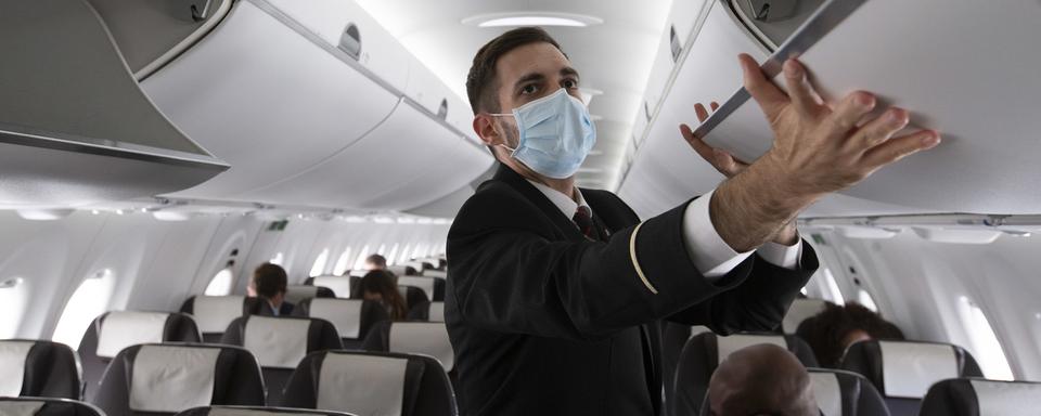 Un membre du personnel de cabine de Swiss dans un vol entre Genève et Londres le 15 juin 2020. [Keystone - Salvatore Di Nolfi]