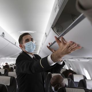Un membre du personnel de cabine de Swiss dans un vol entre Genève et Londres le 15 juin 2020. [Keystone - Salvatore Di Nolfi]