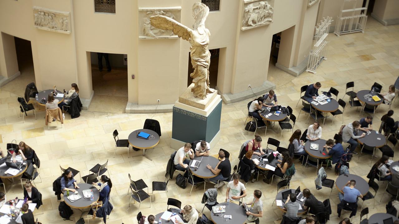 Des étudiants et étudiantes dans l'atrium de l'Université de Zurich. [Keystone - Petra Orosz]
