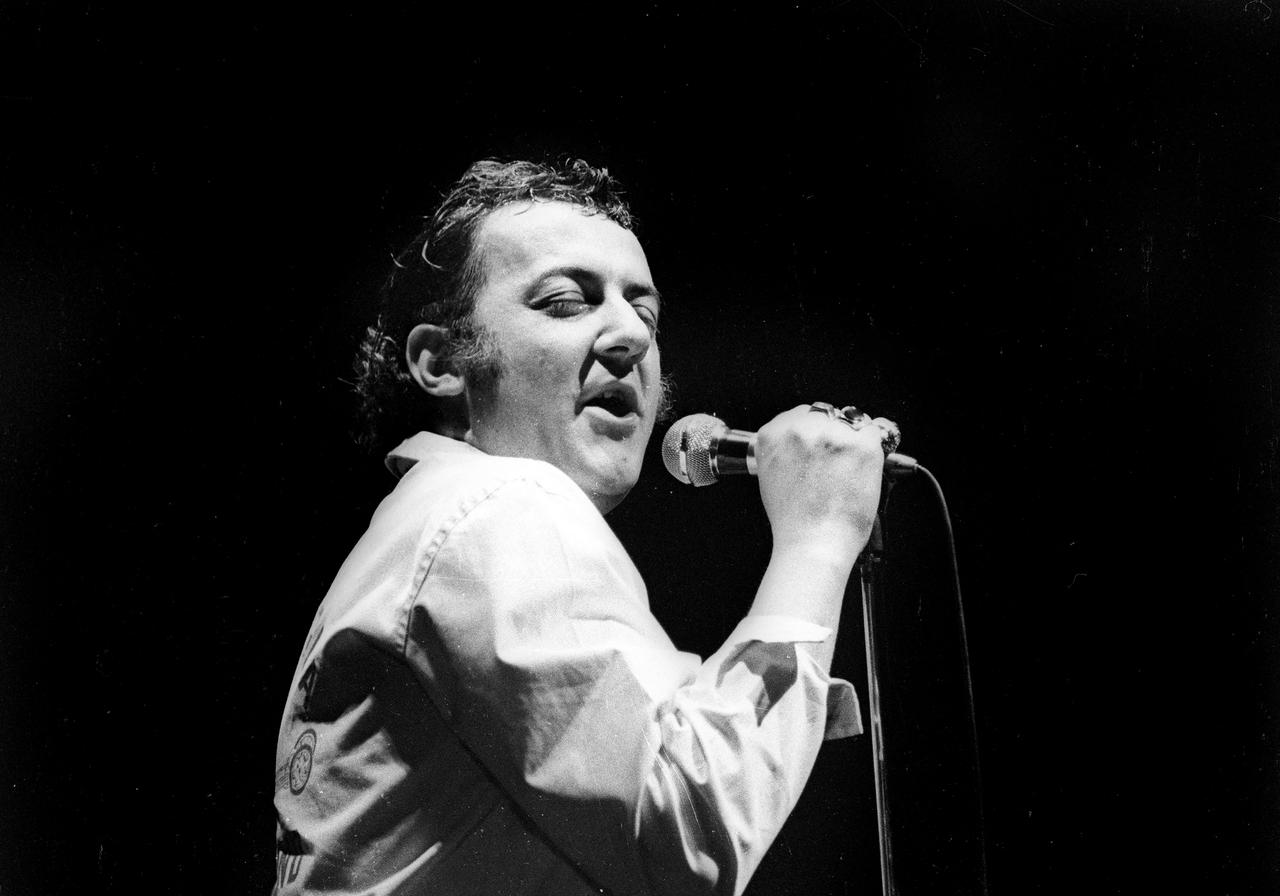 Coluche en 1973 sur la scène de l'Olympia. [Roger-Viollet via AFP - Patrick Ullmann]