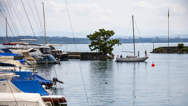 Un bateau sort du port Nid-du-Cro sur le lac de Neuchâtel. [Keystone - Jean-Christophe Bott]