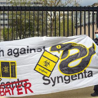 Des participants à la Marche contre Bayer et Syngenta protestent devant le siège de Syngenta à Bâle, le samedi 17 avril 2021. [Keystone - Georgios Kefalas]
