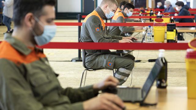 Des agents de la protection civile dans le centre de dépistage de Villars-sur-Ollon. [Keystone - Cyril Zingaro]