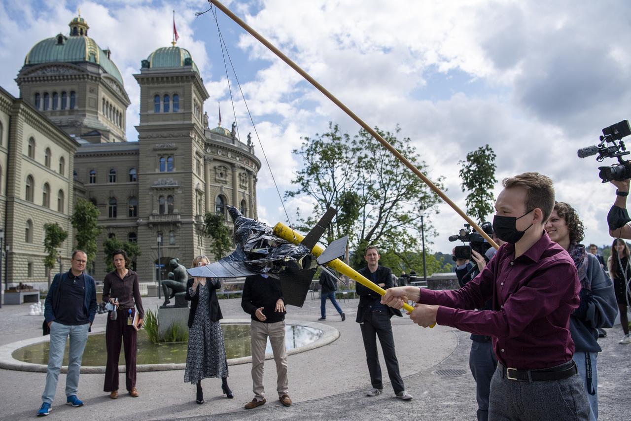 Après leur conférence de presse, les opposants au F-35 ont symbolisé ce "gaspillage massif d'argent" en détruisant une piñata en forme d'avion d'où s'échappent des milliers de faux billets. [Keystone - Peter Schneider]