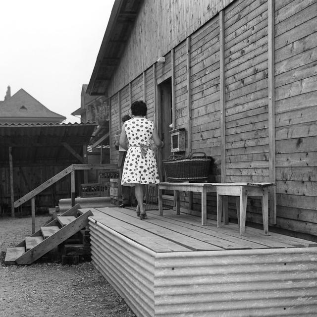 Habitants d'un centre d'hébergement pour travailleurs immigrés italiens à Berne devant leur baraque d'habitation, en juin 1961. [KEYSTONE/PHOTOPRESS-ARCHIV - Widmer]