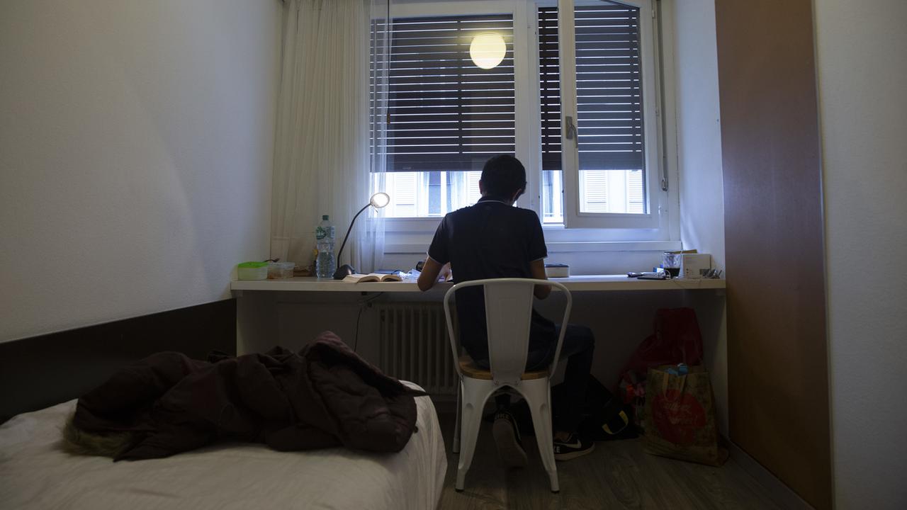 Un sans-abri est photographié dans sa chambre au City Hostel à l'issue de la présentation du bilan de l'hébergement hôtelier de personnes sans-abri à Genève le 9 novembre 2021. [Keystone - Salvatore Di Nolfi]