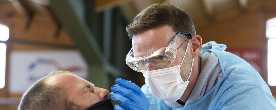 Un agent de santé prélève un échantillon nasal pour réaliser un test rapide à Villars-sur-Ollon, le 5 février 2021. [Keystone - Cyril Zingaro]