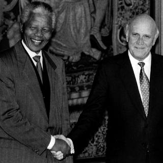 Les deux lauréats du prix Nobel de la paix, le président de l'ANC Nelson Mandela (g) et le président sud-africain Frederik Willem de Klerk, se serrent la main lors de leur rencontre à Oslo, le jeudi 09 décembre 1993. [(AP-Photo/jk NTB/Jon Eeg/ Keystone)]