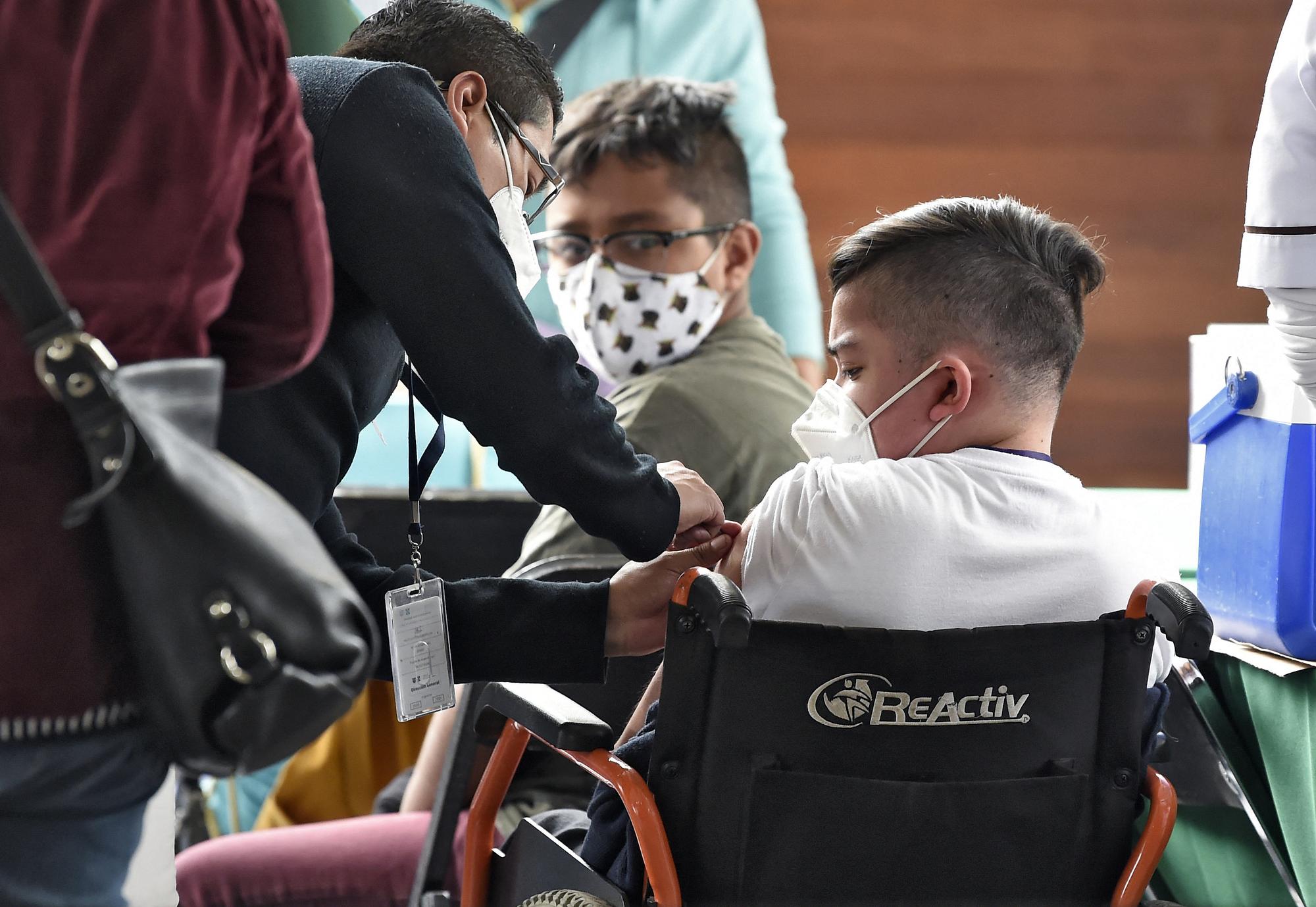 Un mineur reçoit la première dose du vaccin Pfizer/BioNtech à la bibliothèque Vasconcelos de Mexico, le 25 octobre 2021. [AFP - Alfredo Estrella]