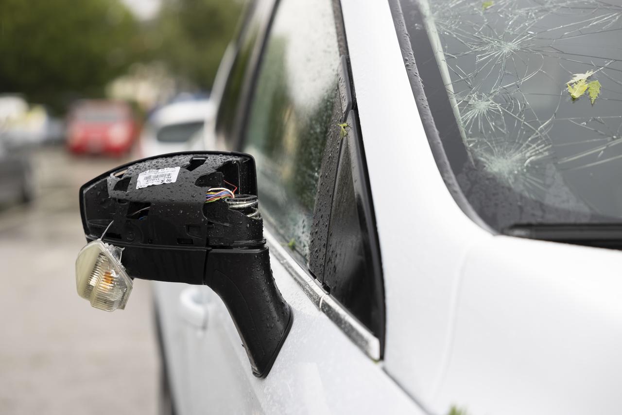 Une voiture fortement endommagée lors d'un violant orage de grêle le 28 juin 2021 à Bulle. [Keystone - Cyril Zingaro]