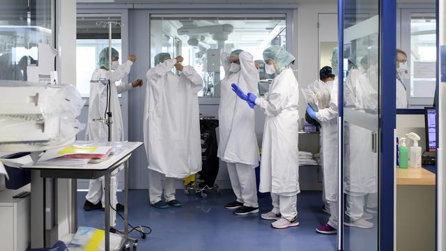 Personnel médical au travail dans l'unité de soins intensifs de l'hôpital "Hopital cantonal fribourgeois (HFR)" pendant l'épidémie de maladie à coronavirus (COVID-19), à Fribourg, en Suisse, lundi 30 mars 2020. [Keystone - Anthony Anex]