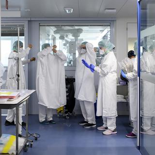 Personnel médical au travail dans l'unité de soins intensifs de l'hôpital "Hopital cantonal fribourgeois (HFR)" pendant l'épidémie de maladie à coronavirus (COVID-19), à Fribourg, en Suisse, lundi 30 mars 2020. [Keystone - Anthony Anex]