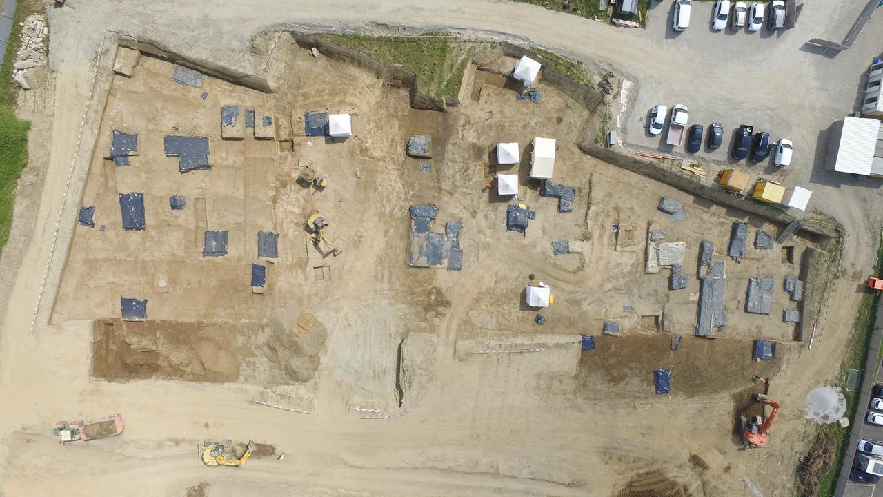 Les secteurs où se trouvent des sépultures à fouiller sont signalés par des bâches plastiques noires. Les tentent indiquent les tombes en cours de fouille. [Archeodunum SA - Y.Buzzi]