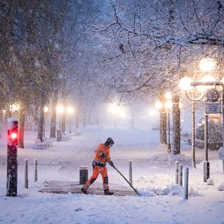 La neige qui tombe actuellement en plaine complique la circulation des véhicules et des piétons au centre ville le vendredi 10 décembre 2021 à Lausanne. [KEYSTONE - Jean-Christophe Bott]