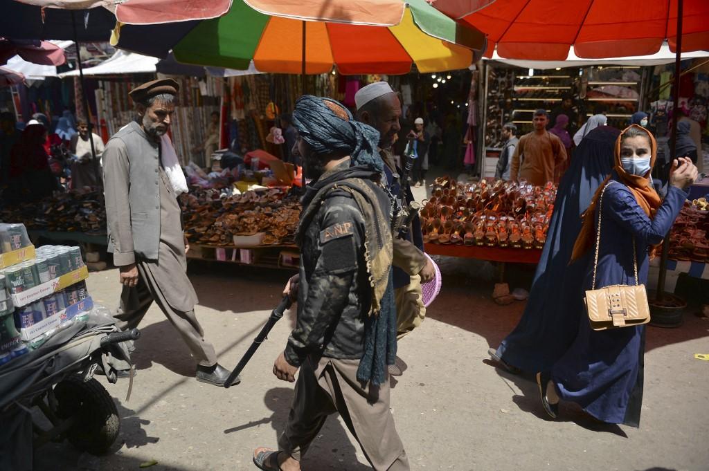Un taliban passe dans le marché Mandawi de Kaboul, le 1er septembre 2021. [AFP - Hoshang Hashimi]