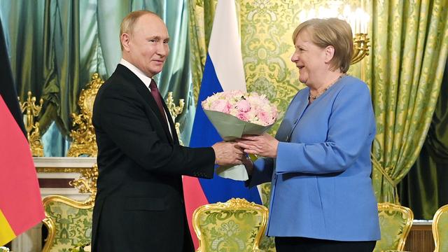 Vladimir Poutine a accueilli Angela Merkel avec un bouqet. [Kremlin Pool/Sputnik/AFP]