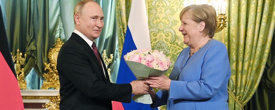 Vladimir Poutine a accueilli Angela Merkel avec un bouqet. [Kremlin Pool/Sputnik/AFP]