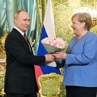 Vladimir Poutine a accueilli Angela Merkel avec un bouqet. [Kremlin Pool/Sputnik/AFP]
