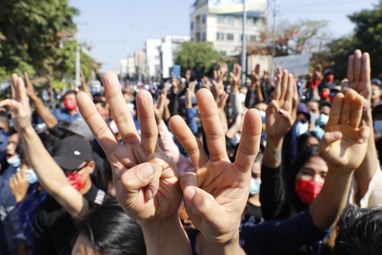 Le salut à trois doigts est utilisé par les manifestants comme un signe de résistance. [KEYSTONE - Keystone/AP Photo]