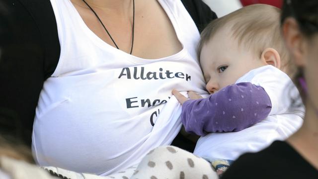 Une mère allaite son enfant, durant une flash mob en septembre 2014 à Lausanne. [Keystone - Laurent Gillieron]