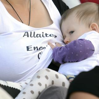 Une mère allaite son enfant, durant une flash mob en septembre 2014 à Lausanne. [Keystone - Laurent Gillieron]