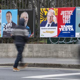 Une personne passe devant les affiches des candidats pour l'élection complémentaire d'un membre du Conseil d'Etat, ce jeudi 11 février 2021 à Genève. [KEYSTONE - MARTIAL TREZZINI]