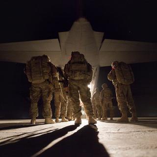 Des soldats américains embarquent dans un avion pour quitter l'Afghanistan en 2011 à la fin de leur mission d'une année. [Keystone - AP Photo/David Goldman]