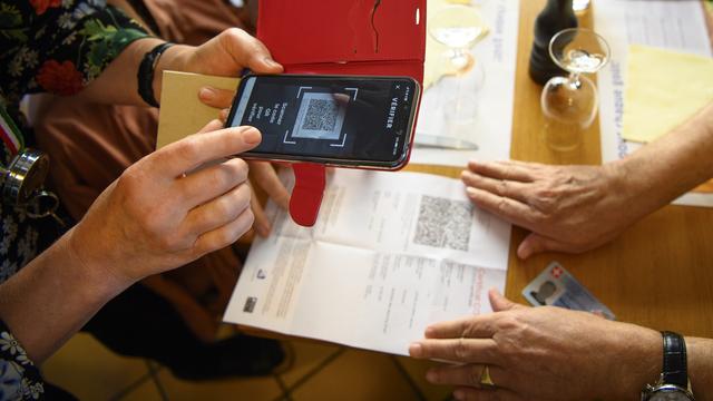 Une serveuse vérifie un certificat Covid dans un restaurant lausannois, le 13 septembre 2021. [Keystone - Laurent Gillieron]