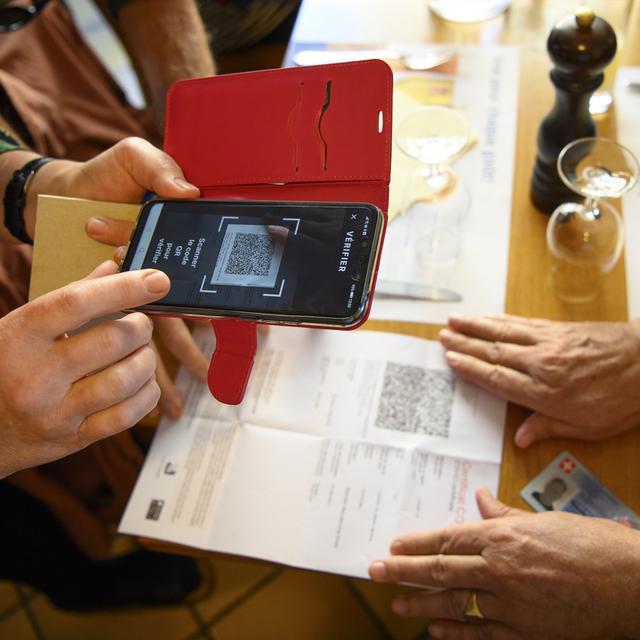 Une serveuse vérifie un certificat Covid dans un restaurant lausannois, le 13 septembre 2021. [Keystone - Laurent Gillieron]