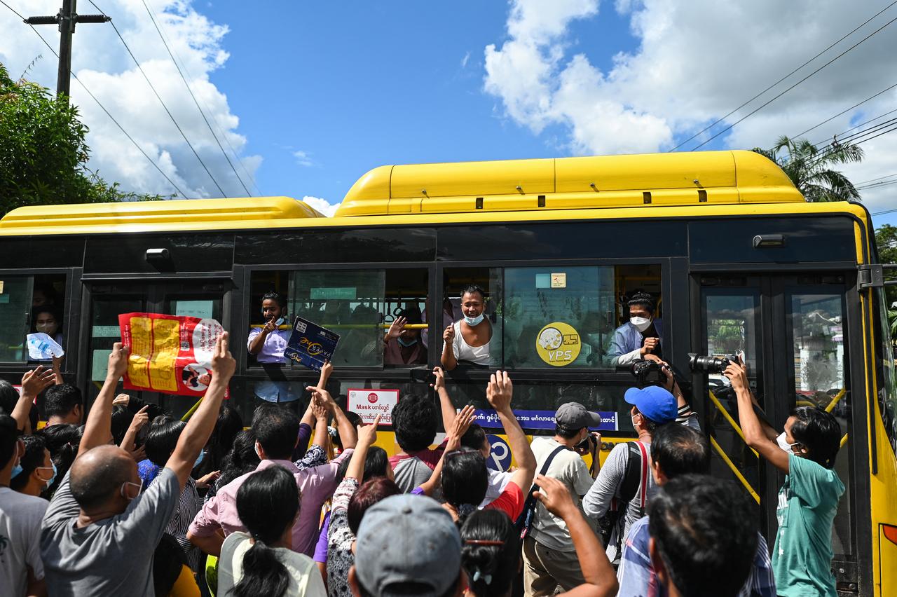 Des détenus libérés de la prison d'Insein célèbrent avec la foule depuis un bus à Yangon, en Birmanie, le 19 octobre 2021. [AFP - STR]