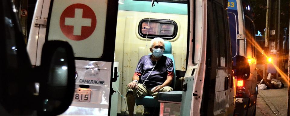 Un patient attend une aide médicale à l'intérieur d'une ambulance, à l'extérieur de l'hôpital Boa Viagem. Brésil, le 20 mars 2021. [Keystone/epa - Genival Paparazzi]