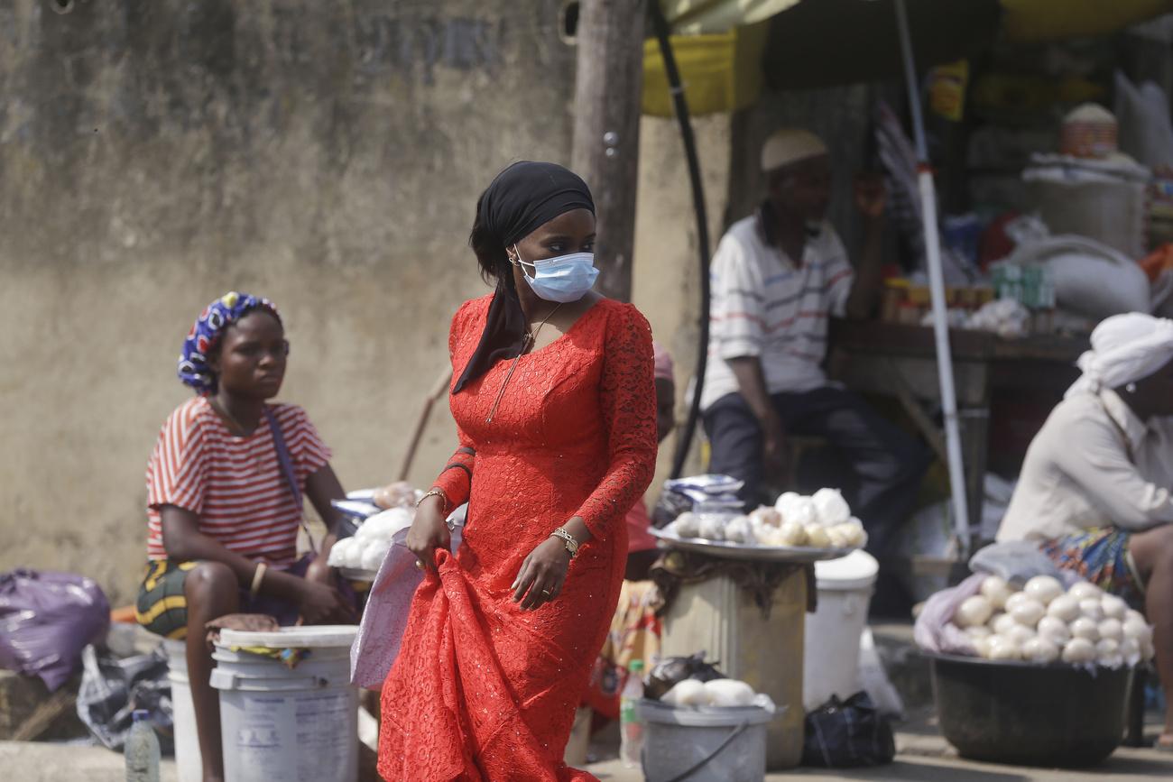 Une femme porte un masque dans un marché de Lagos, au Nigeria, le 24 décembre 2020. [Keystone/AP photo - Sunday Alamba]